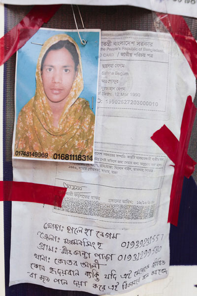 <p>[Text, including that peeping from behind the photograph] <br />Government of the People’s Republic of Bangladesh<br />NATIONAL ID CARD<br />[front]<br />NAME: Saleha Begum<br />FATHER: Abdul Gafur<br />MOTHER: Nurjahan Begum<br />Date of Birth: 12 Mar 1990<br />ID NO: 19902627203000010<br />[back]<br />This card is the property of the government of Bangladesh.  If the card is not found on the user, you are requested to submit it at the nearest post office.<br />ADDRESS: VILLAGE/ROAD: B-78/7 Binod Baid, POST OFFICE: Savar – 1340, Savar Municipality, Savar, Dhaka<br />Signature of the authorising officer [illegible]<br />Date given: 19/10/2010<br />~ ~ ~ ~ ~ ~ ~ ~ ~ ~ <br />[Handwritten]<br />Mosa[mmat] Saleha Begum<br />DISTRICT: Mymensingh    01939231557<br />VILLAGE: Mirkanda Para    01931299580<br />THANA: Qutb Ali<br />If any kindhearted person finds this girl dead or alive, please call this number.</p>